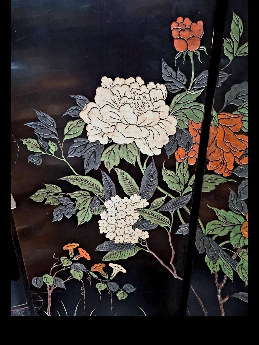 A large decorative screen in Chinese lacquer with both sides different floral scenes guilded and polychrome colours.