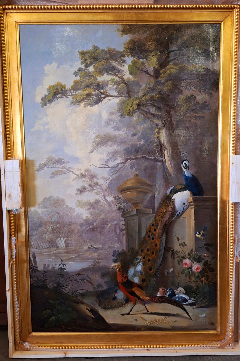 Large and very decorative painting with peacock and birds in a guilded frame from wood with stucco