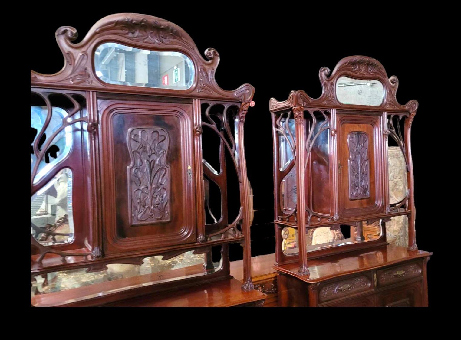 Very nice pair of Mahogany carved cabinets in ArtNouveau style with carved paneled doors and beveld mirrors.